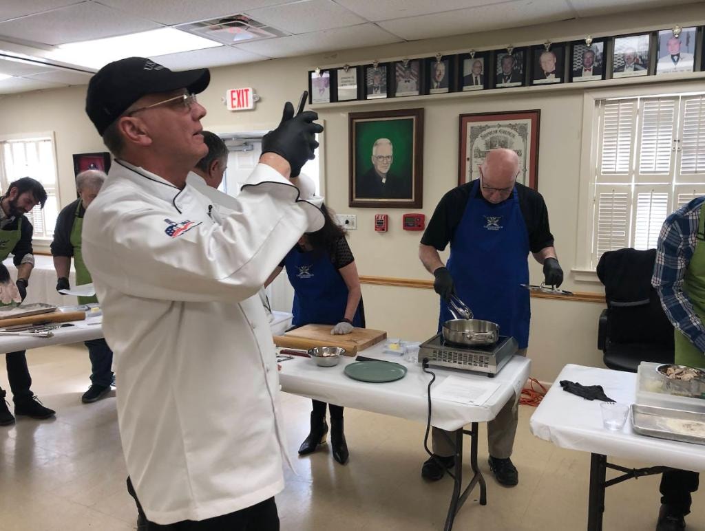 Chef instructing members during the Italian cooking demonstration