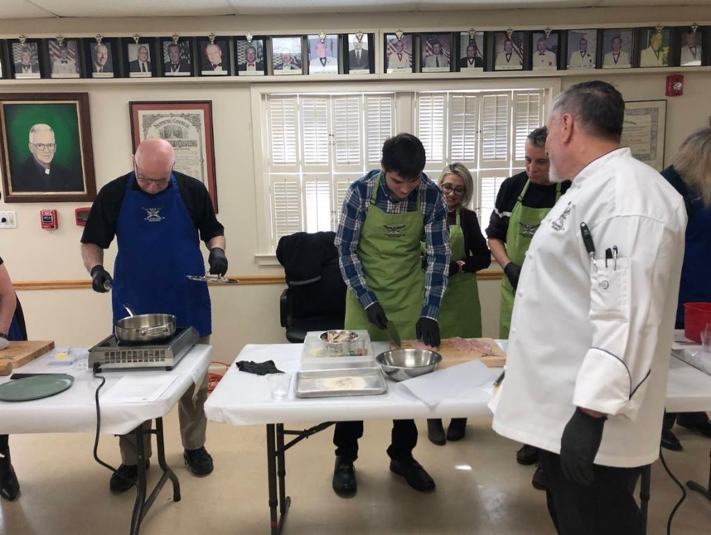 Members learning knife skills at the lodge cooking class
