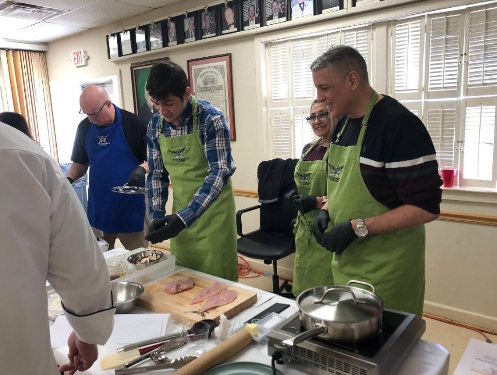 Members preparing Italian dishes at the cooking demonstration
